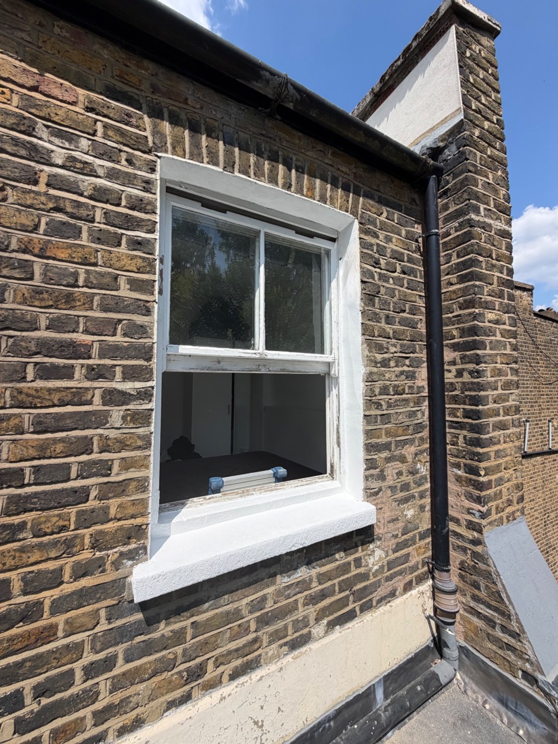 Repaired and decorated window surround and sill, retaining the existing window